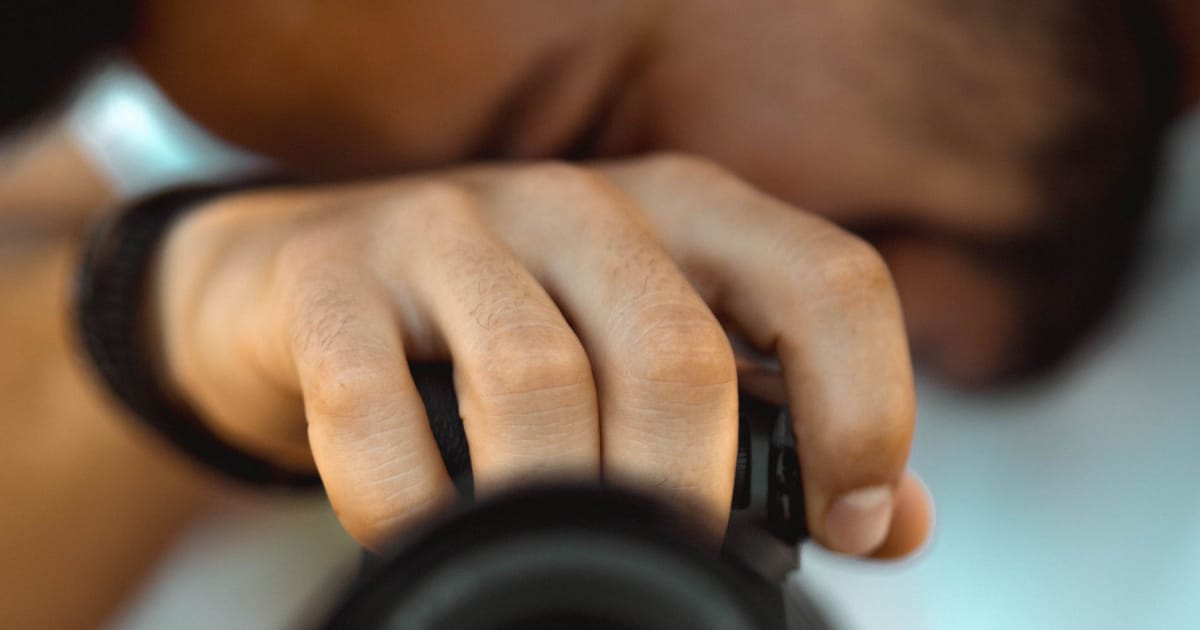 A photographer adjusting a lens